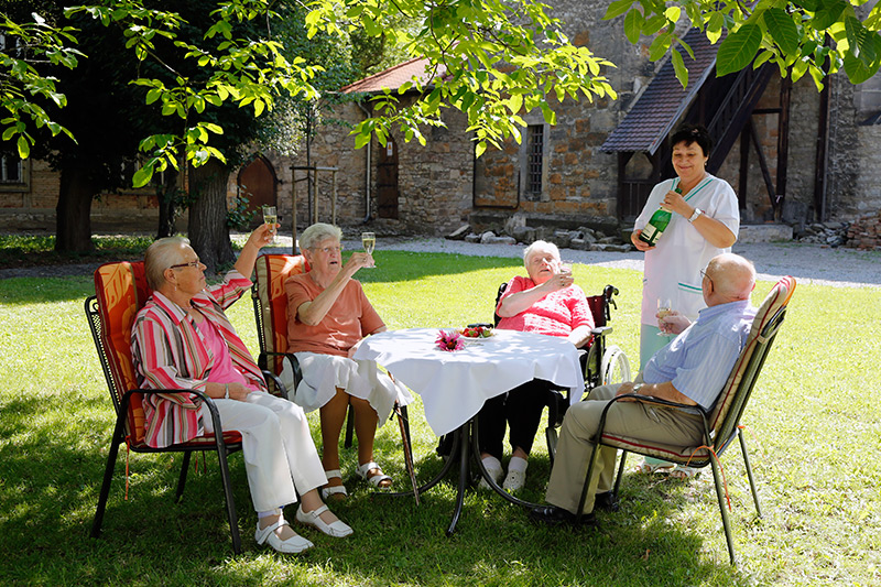 Senioren sitzen im Garten